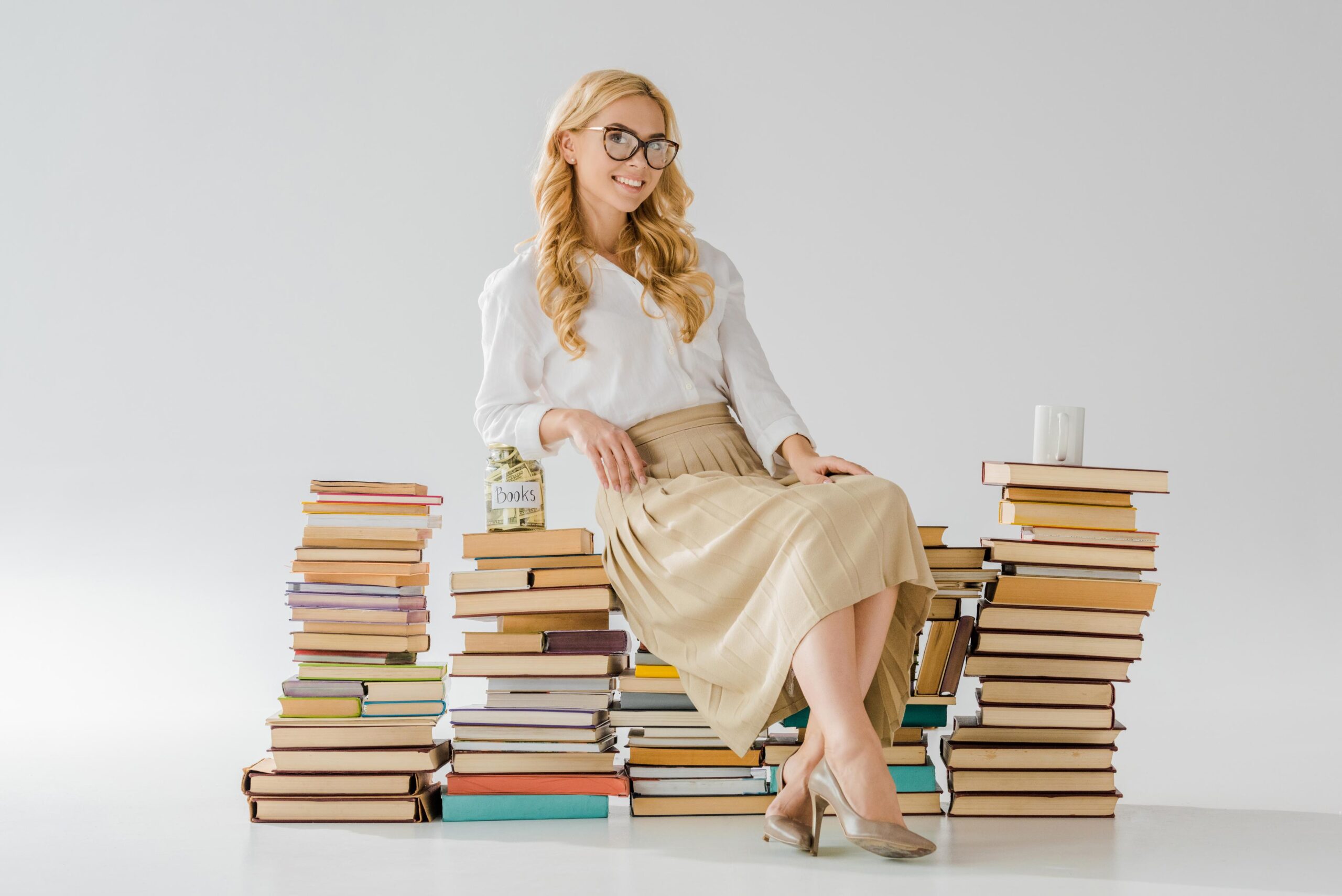beautiful-woman-in-glasses-sitting-on-books-with-s-2023-11-27-05-23-04-utc (2) - Republic Book Publishers Title & Author Marketing